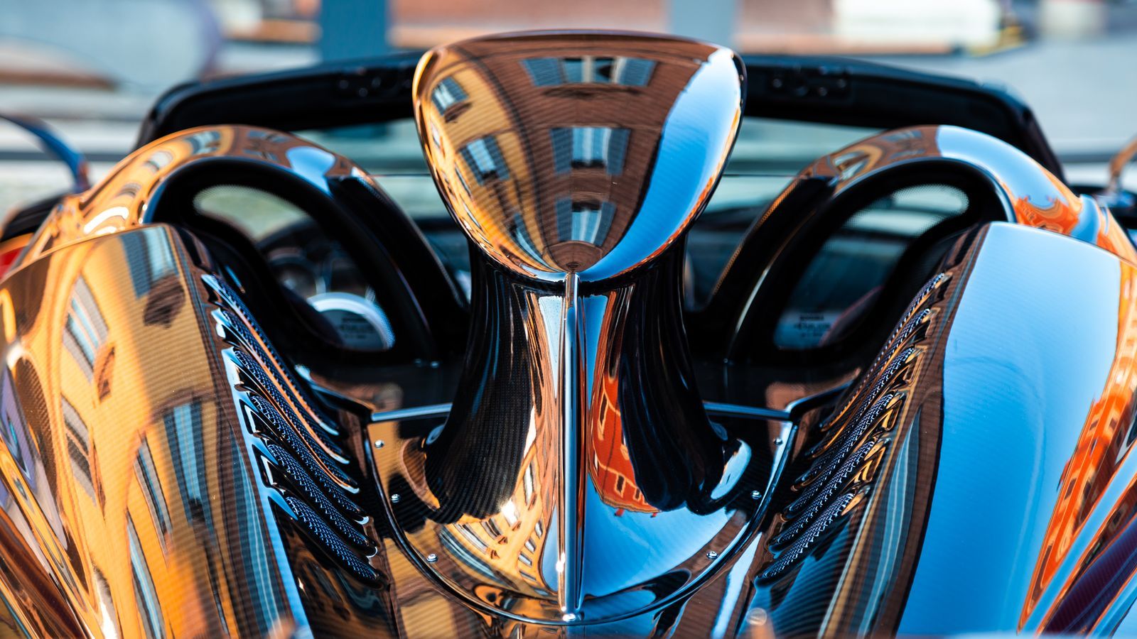 The polished blue paint and chrome grille of a classic sports car catching the light