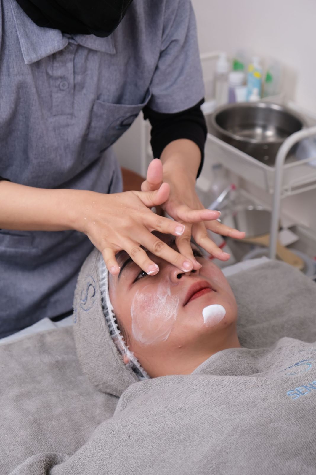 A therapist applying a treatment mask during a signature facial