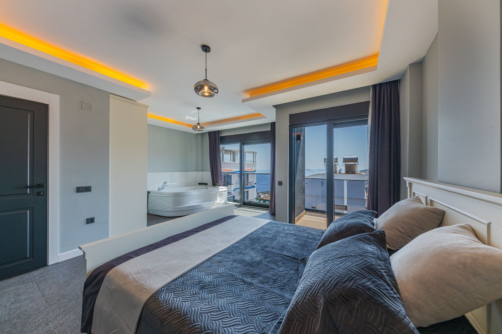 A top-floor bedroom at The Meridian with a king bed and doors opening onto a private balcony
