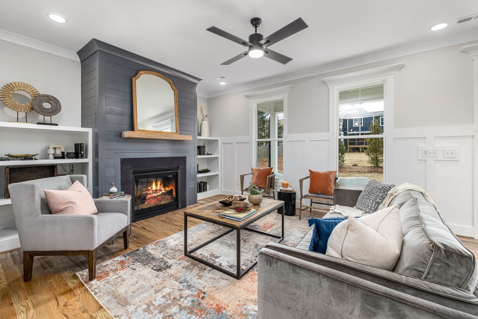 A sitting room with grey sofas, a fireplace and a wood floor