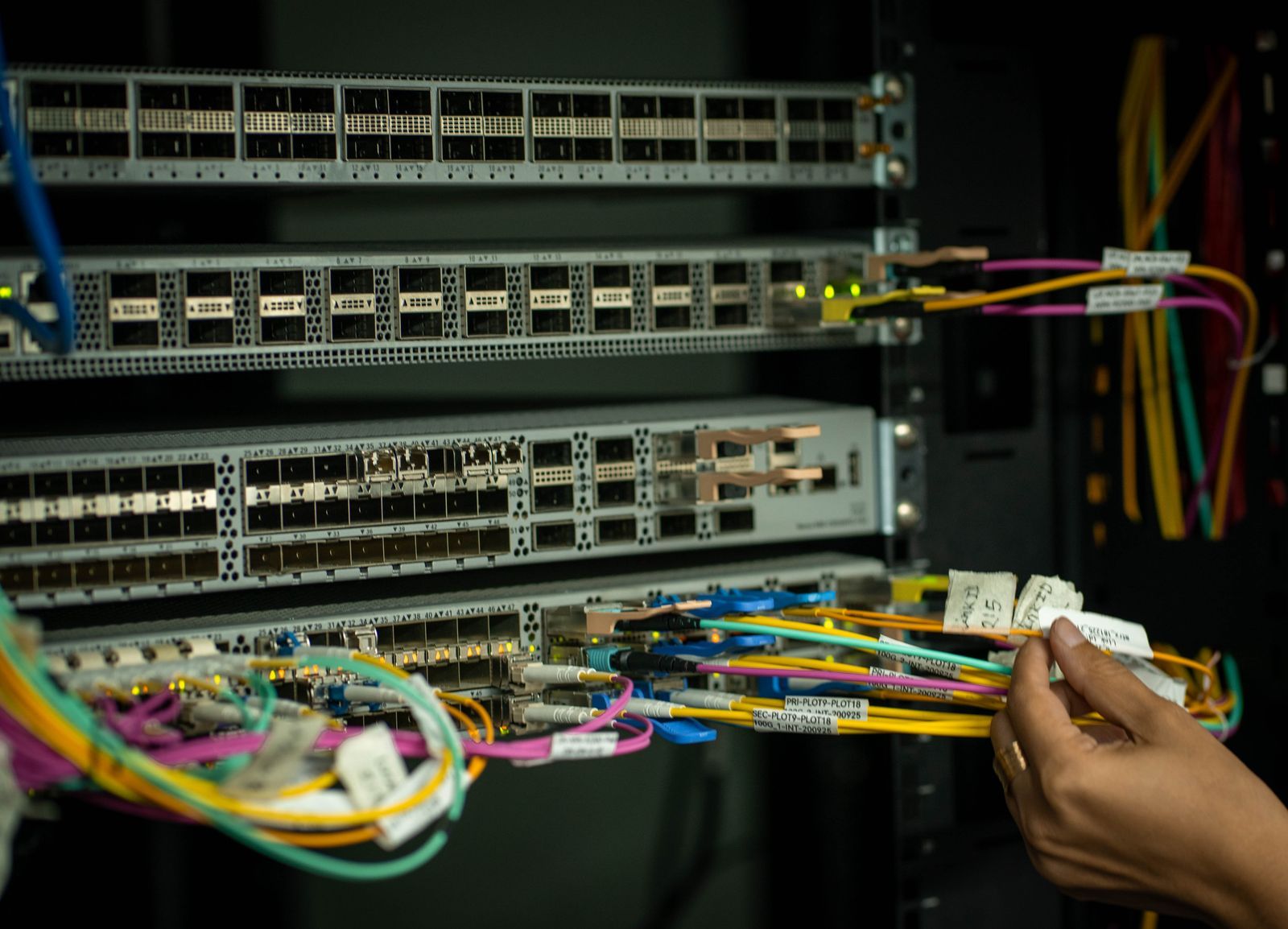 An engineer re-terminating network cables in a client comms room