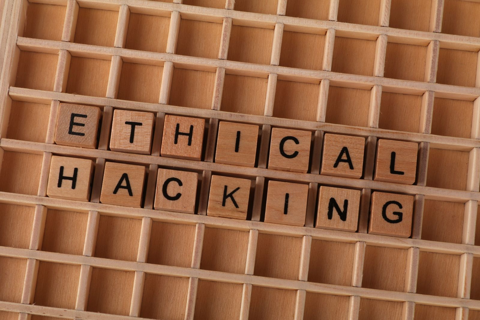 Wooden blocks spelling out ethical hacking next to a keyboard, used in Nexis security awareness training
